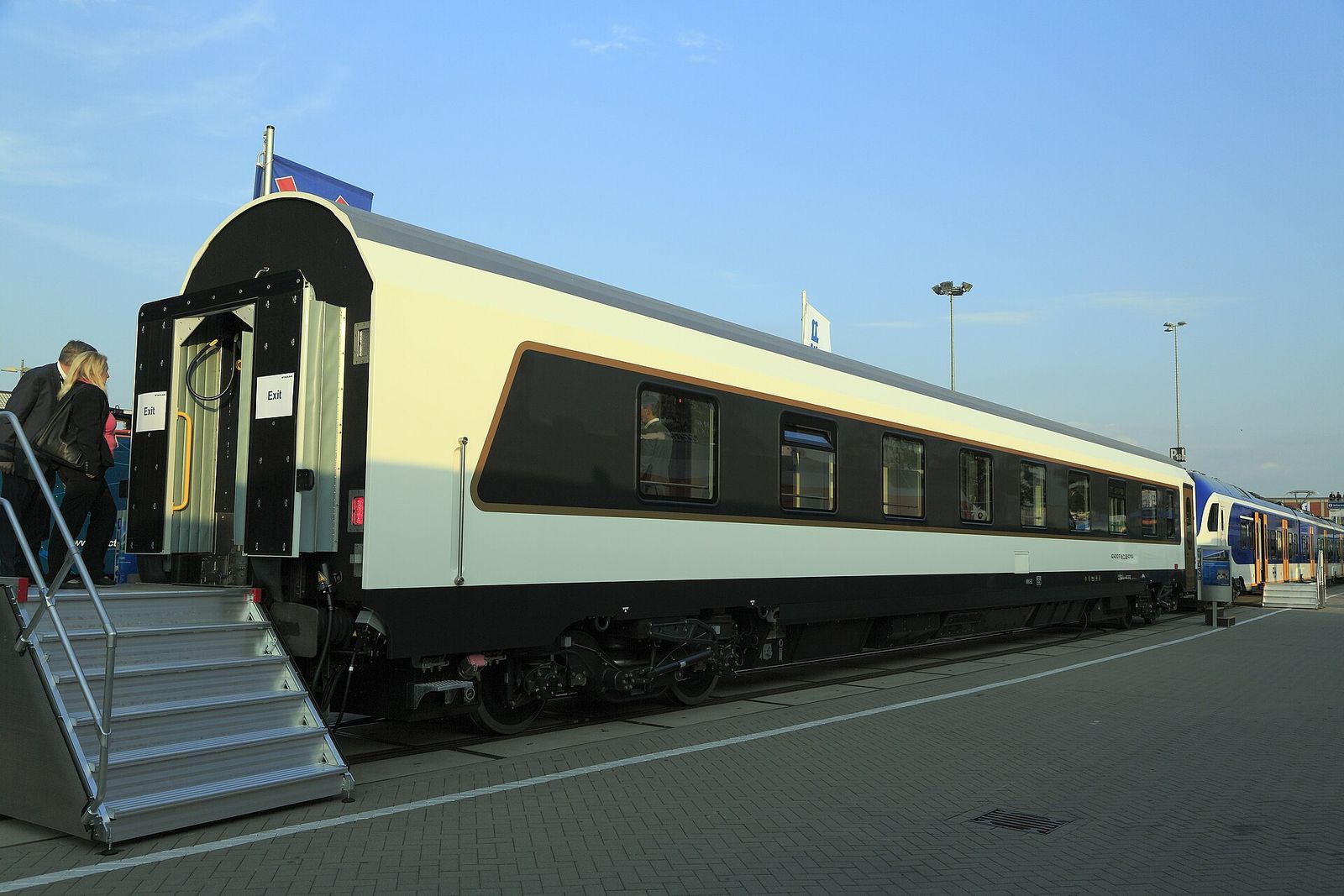 A cream and black Stadler sleeping car built for Azerbaijan Railways, with its boarding steps lowered
