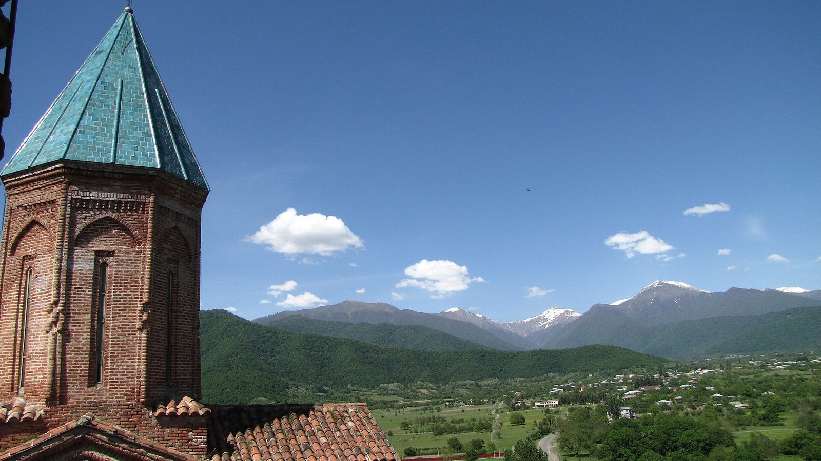 The green-roofed brick tower of the Church of the Archangels at Gremi, above the Alazani Valley and the Caucasus