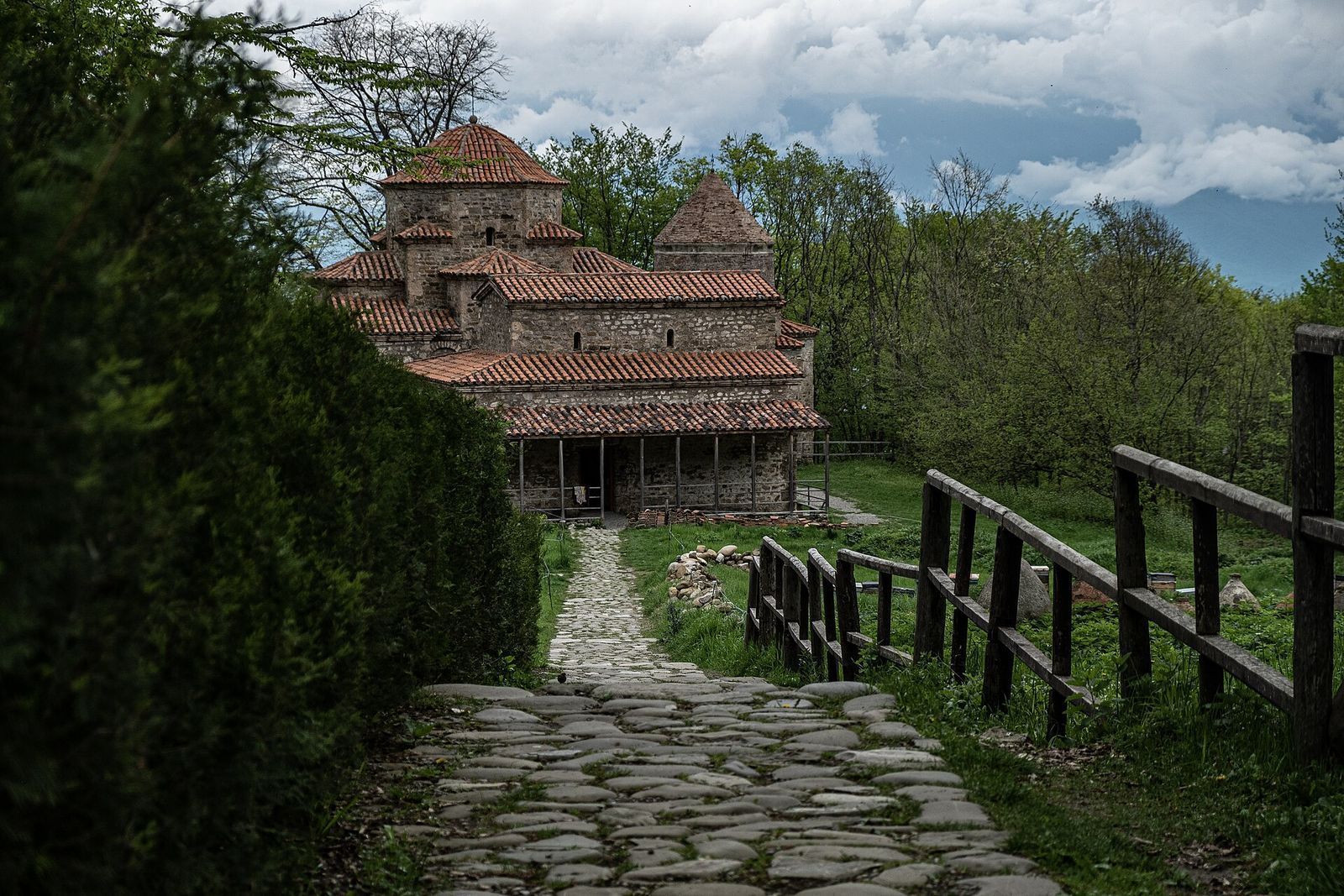 The domed stone church of Old Shuamta monastery at the end of a cobbled path in the forest above Telavi