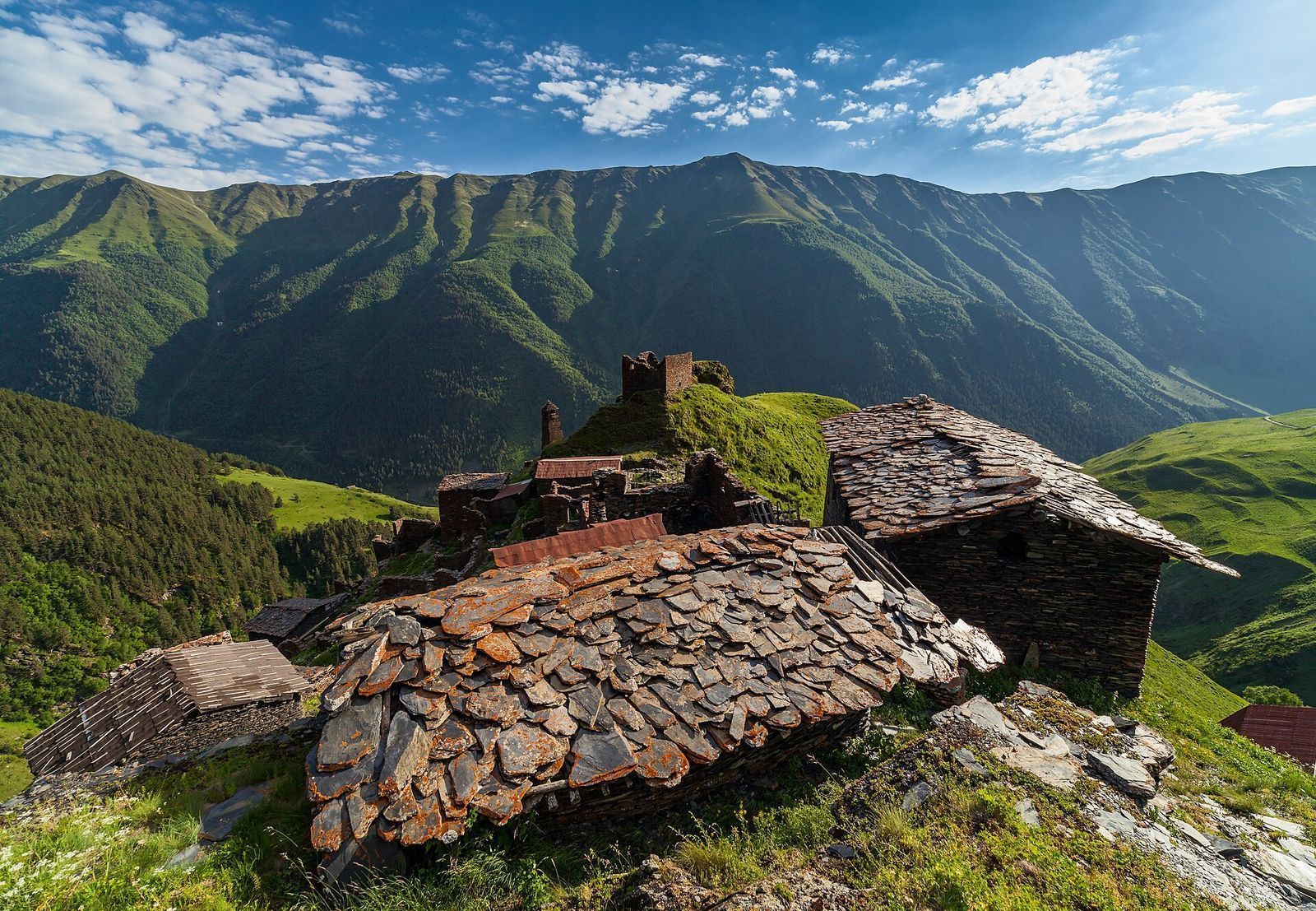 Slate-roofed stone houses and a ruined tower in Kvavlo, high above the forested Pirikiti valley