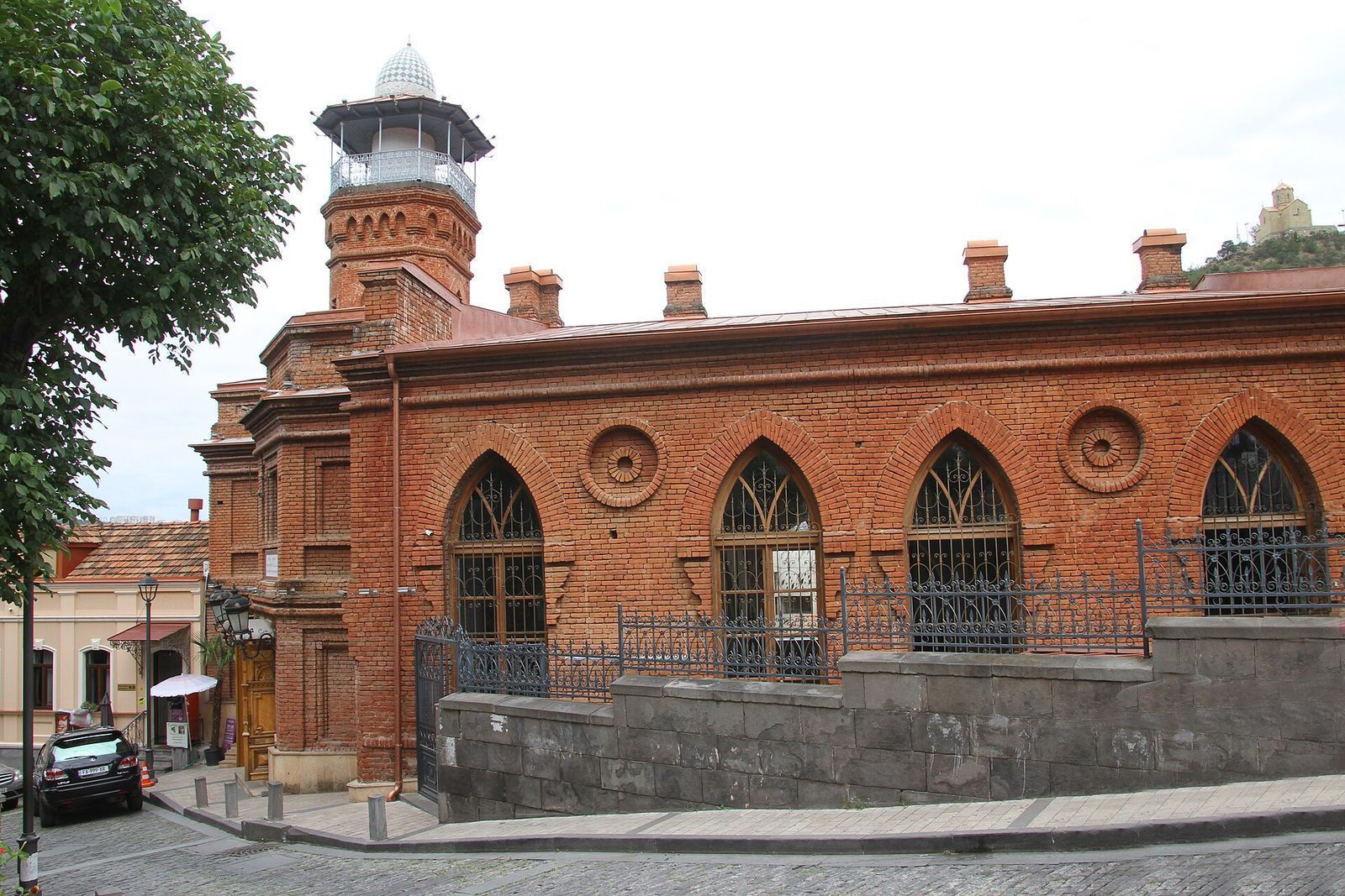 The red-brick Jumah Mosque on Botanikuri Street, with its minaret and pointed arched windows