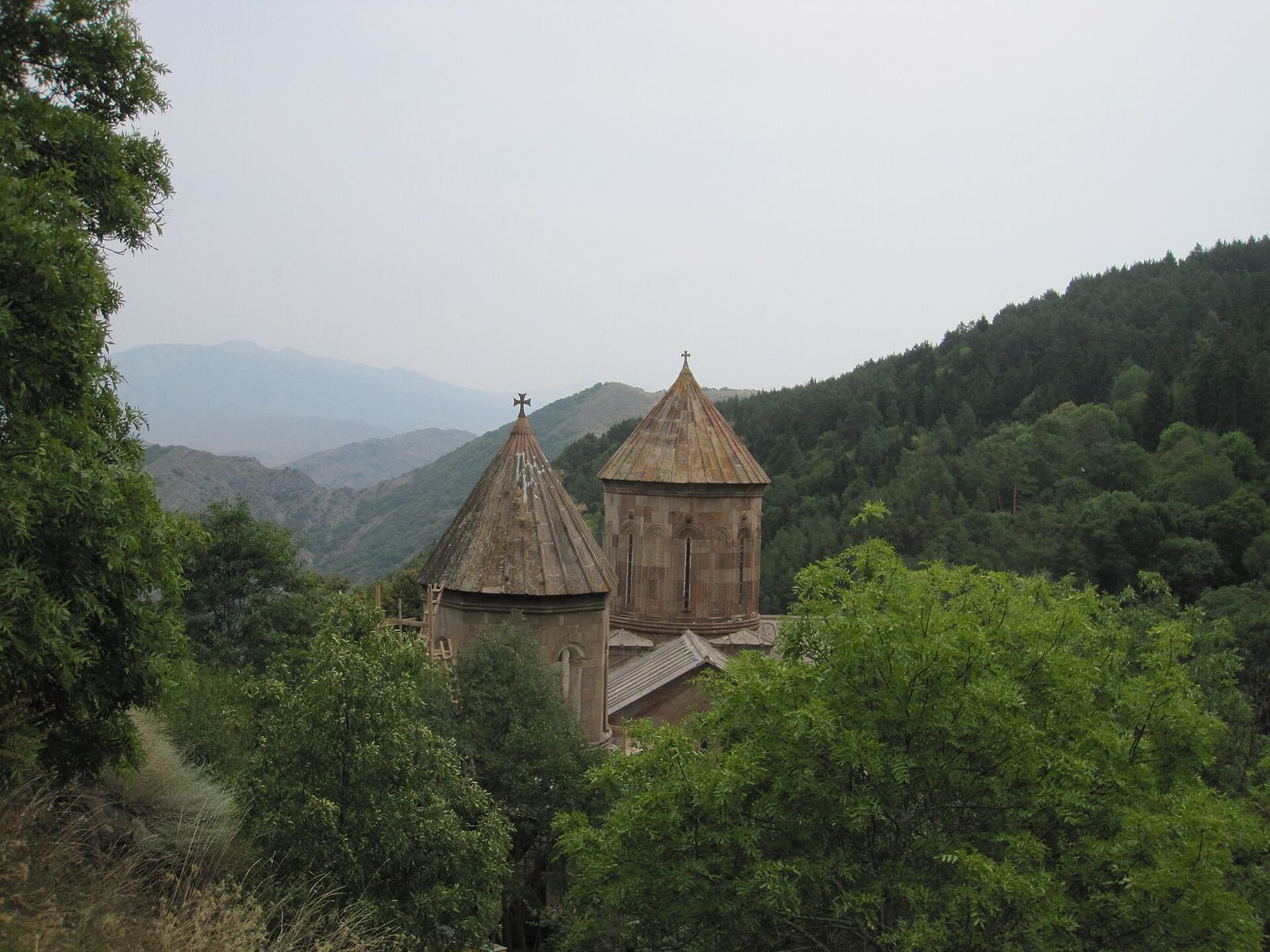 The stone churches of Sapara Monastery with their conical domes among forested hills