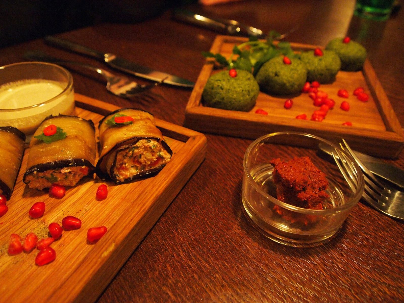 Plates of pkhali and badrijani nigvzit with ajika on a Georgian table