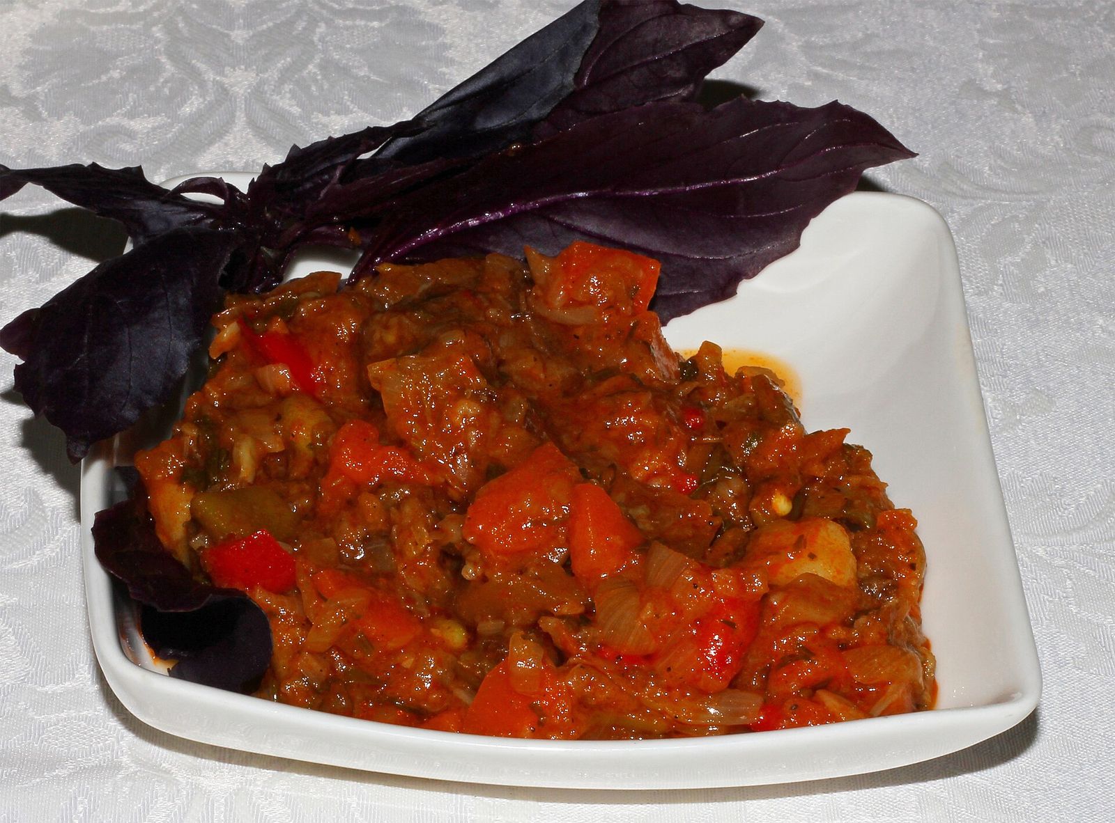 A dish of ajapsandali, the Georgian eggplant, pepper and tomato stew, garnished with purple basil