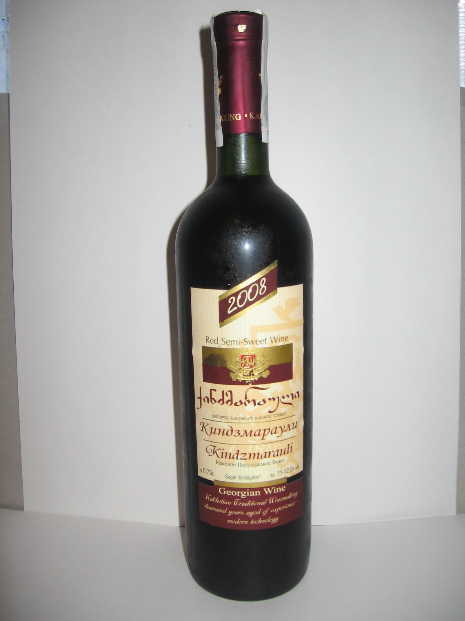 Bottle of Kindzmarauli red semi-sweet wine with its label in Georgian, Russian and English