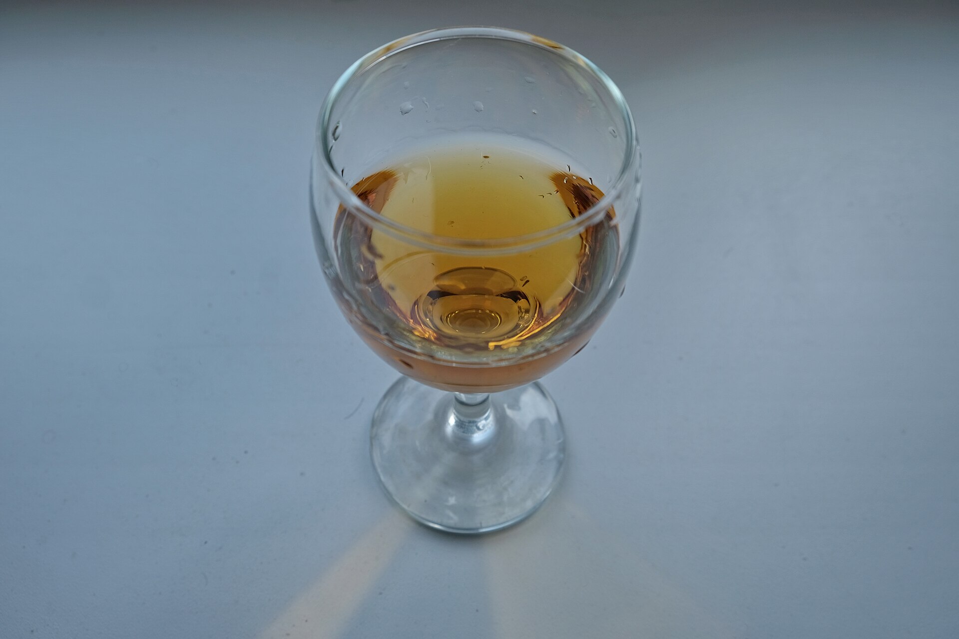 A glass of amber qvevri wine made from Rkatsiteli